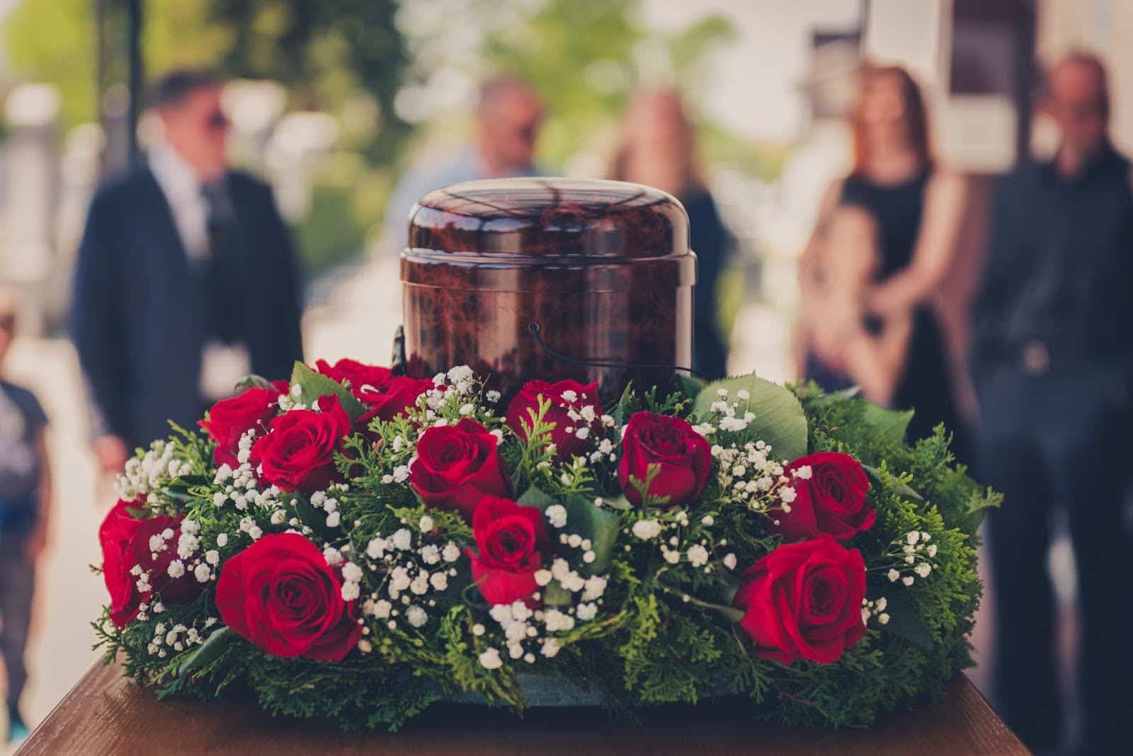 Funerary cremation urn and flowers at funeral