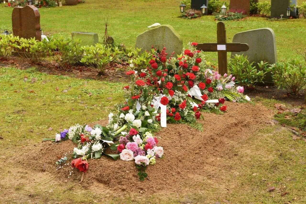 Wide view of a cemetery with graves and green lawn