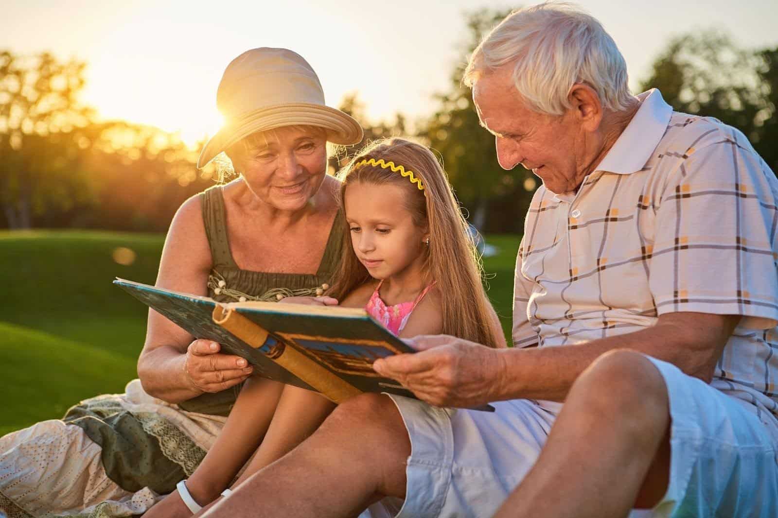 Grandparents reading book with granddaughter, representing family legacy